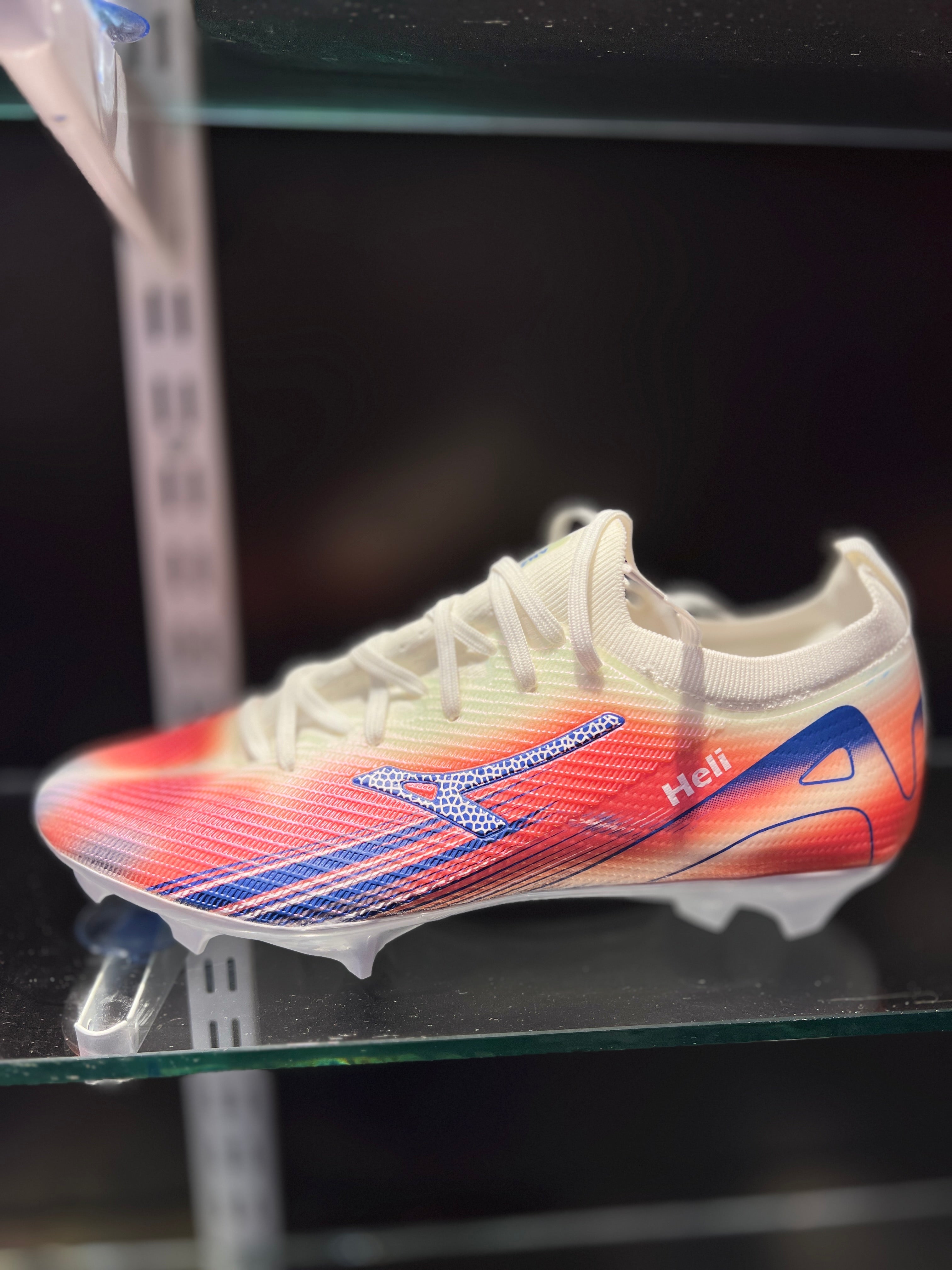 Player wearing ANZA Elite football boots kicking soccer ball