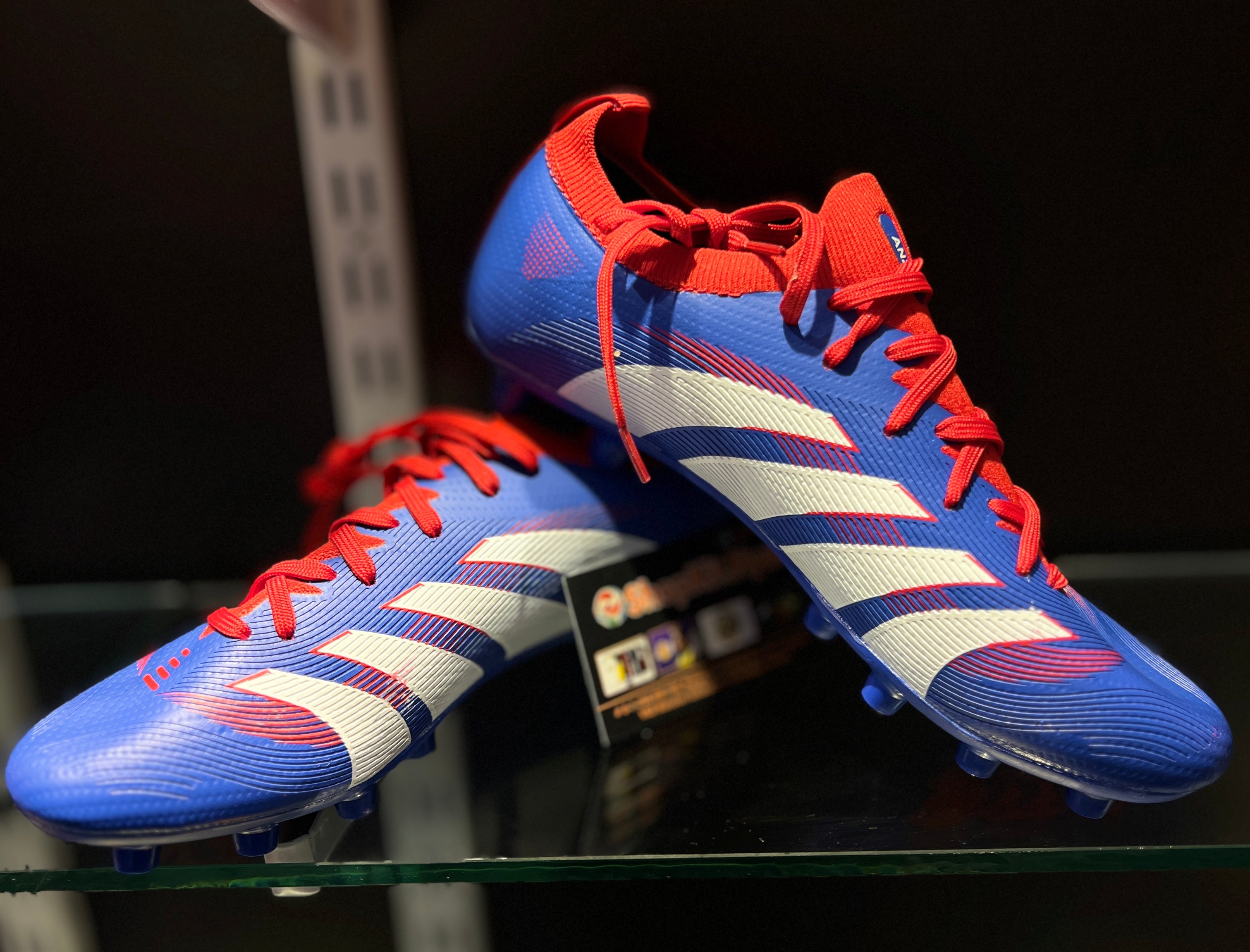 Player wearing Anza Switch football boots kicking ball during match